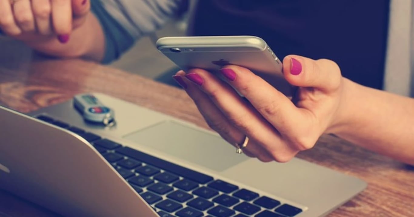 Frauenhand die ein Smartphone hält.